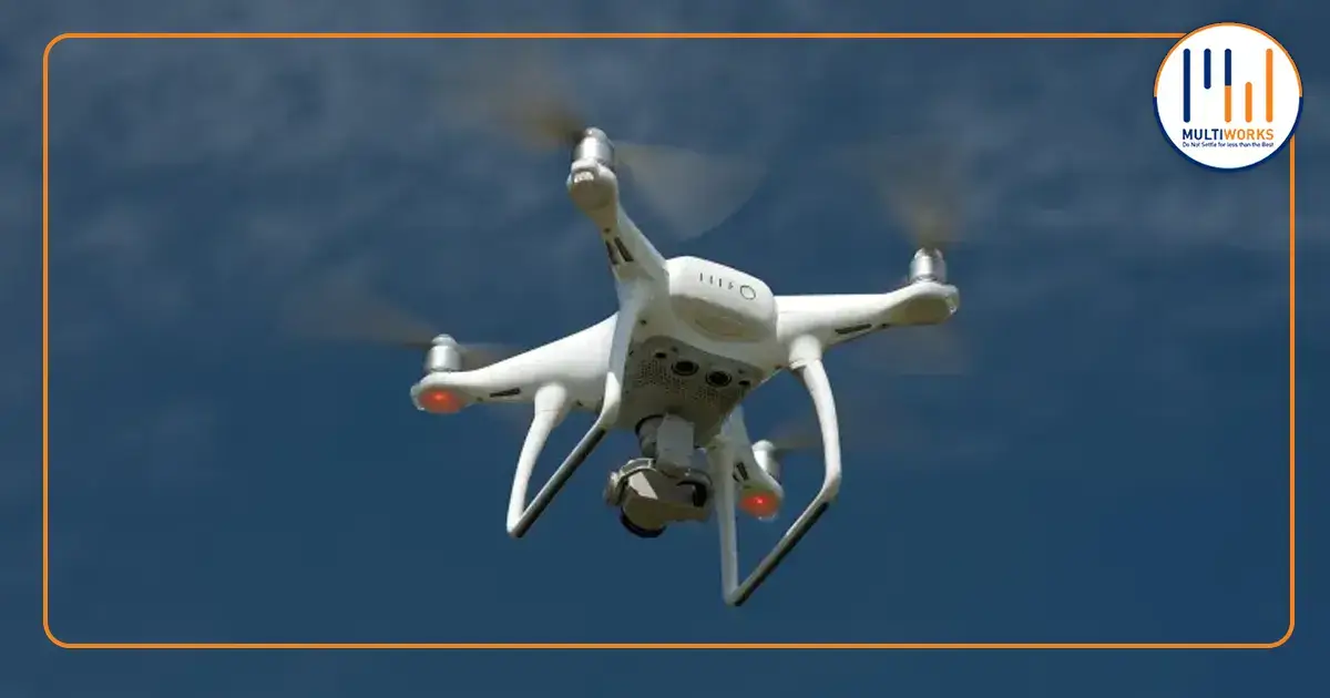 A white drone flying in the sky, used by the CDA for aerial seeding to reforest and conserve the environment in Islamabad.